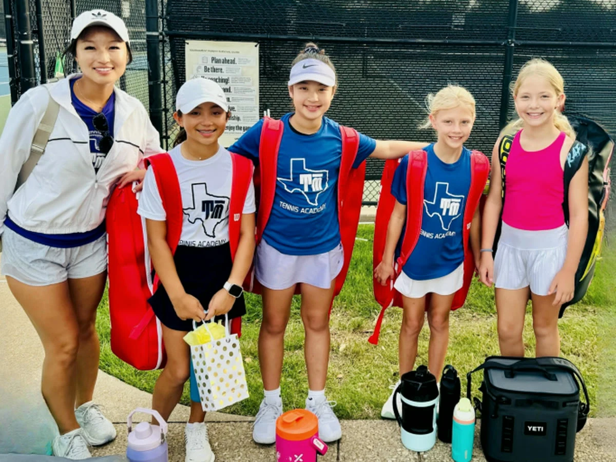 T Bar M junior players and their coach courtside in Dallas